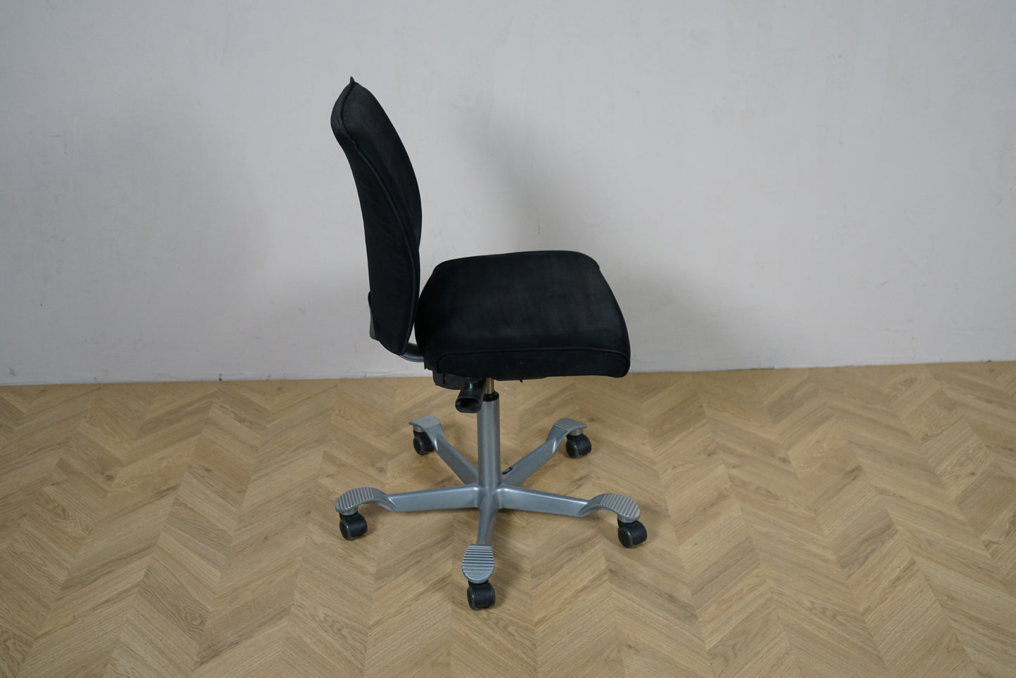 HÅG H05 kontorstol set fra siden med ergonomisk design og gråt fodkryds