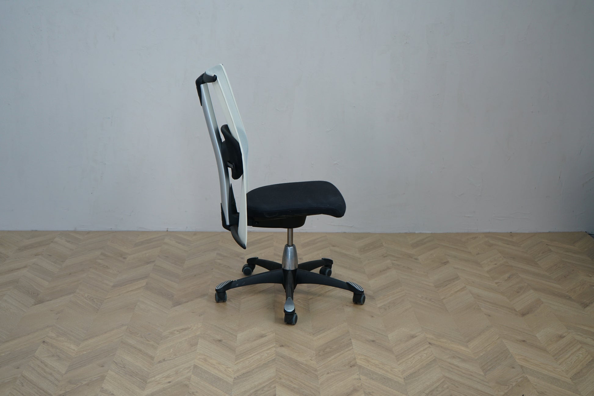 HÅG H09 ergonomisk kontorstol set fra siden med sort sæde og sort metalfod