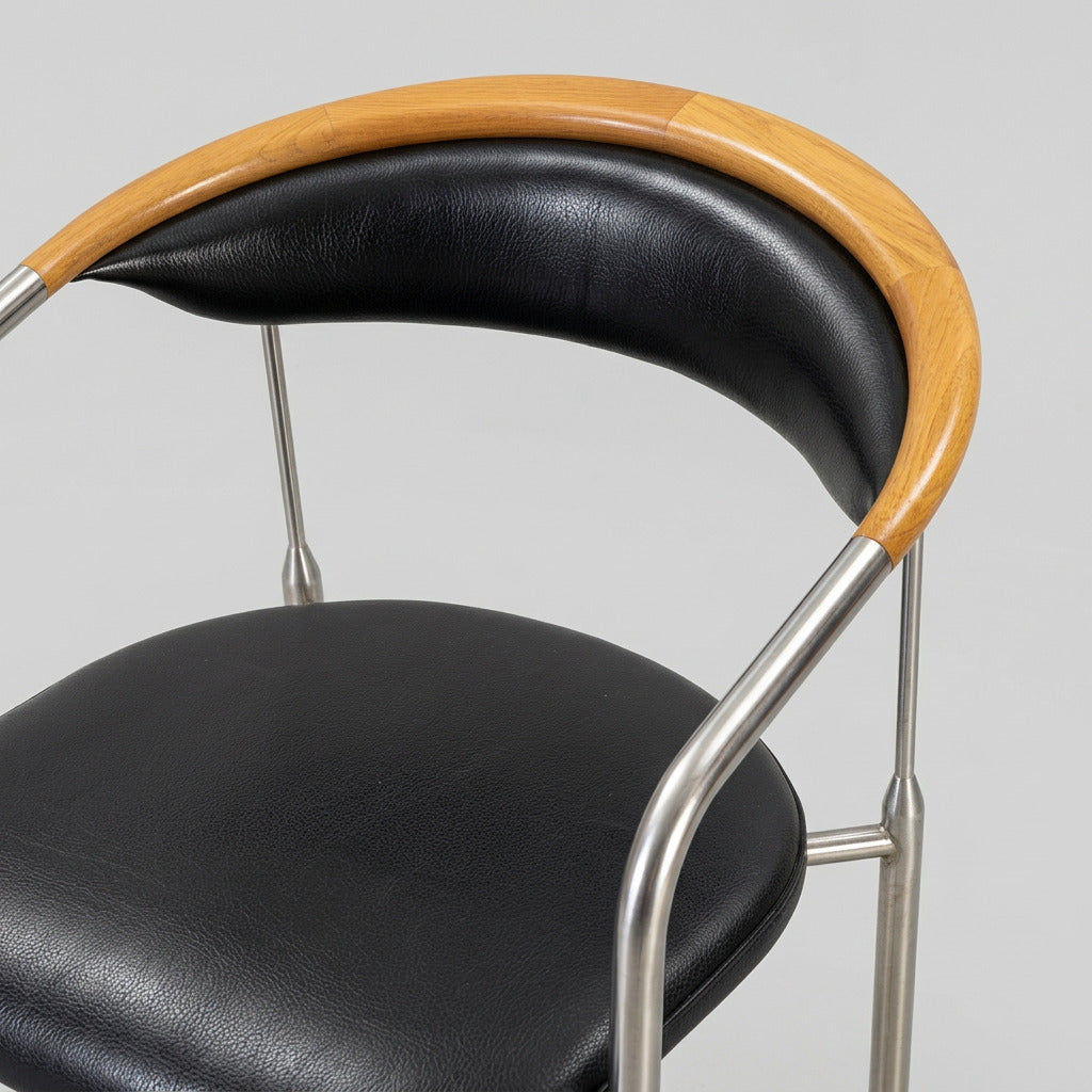 Nærbillede af Henrik Tengler Chairman designerstol med sort læderbetræk, kopstykke i ahorn og detaljer i børstet stål.