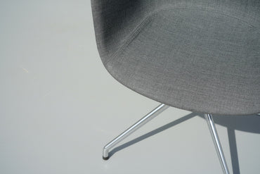 Close-up af HAY About A Chair 21 AAC med grå uldpolstring og krom drejestel