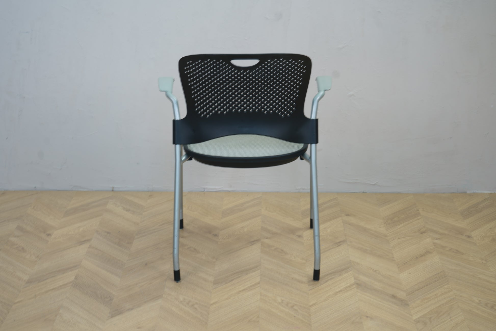 Herman Miller Casper konferencestol set bagfra med perforeret sort plast ryglæn og gråt metalstel.
