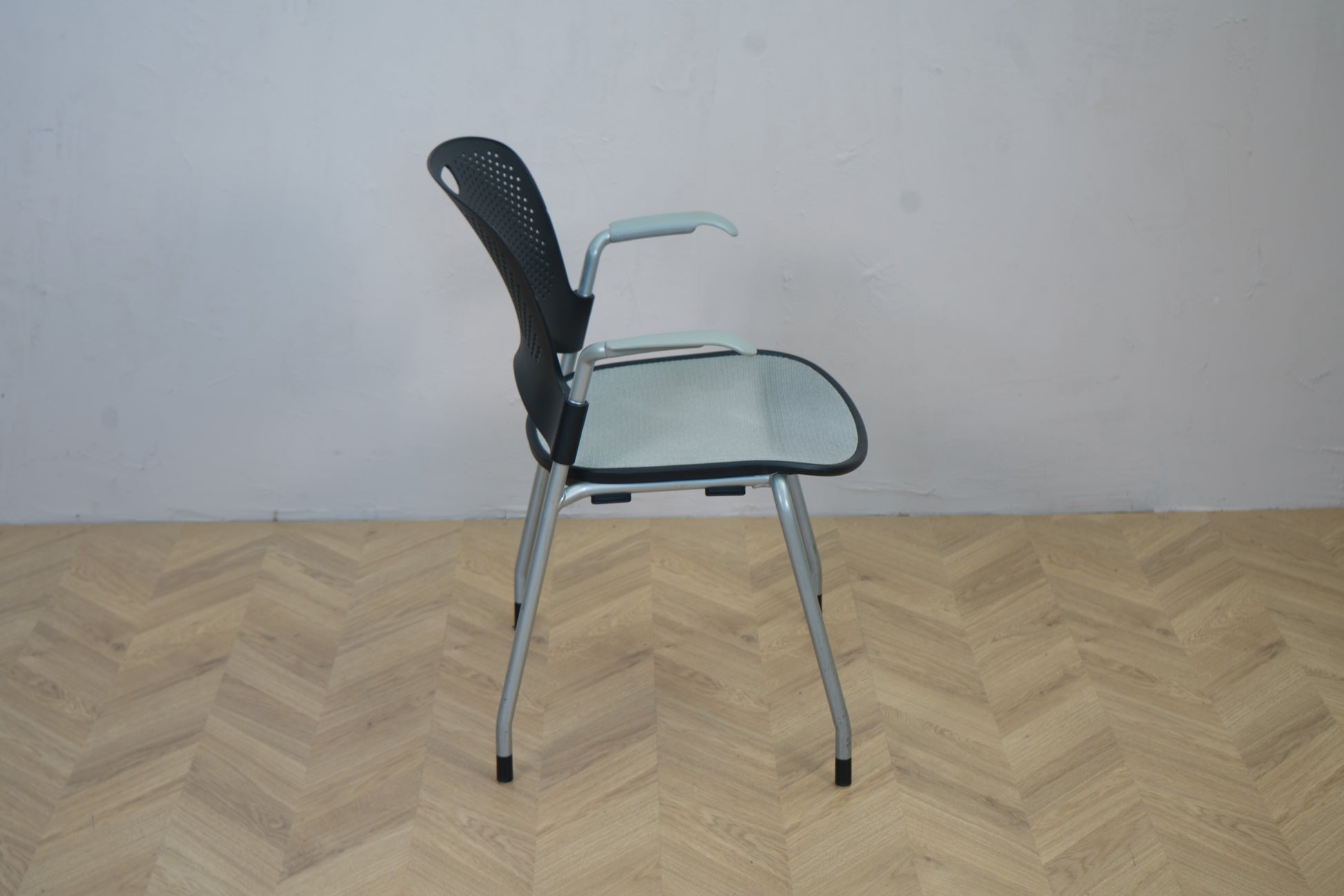 Herman Miller Casper konferencestol set fra siden, viser armlæn og let buet ryglæn i sort plast.