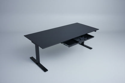 Holmris B8 hæve-sænkebord set skråt med sort linoleumsbordplade og integreret skuffe