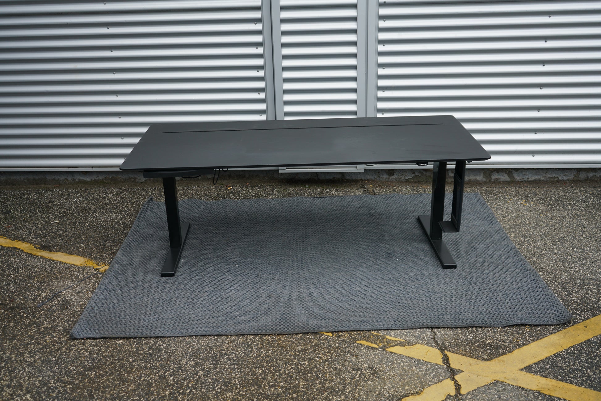 Holmris B8 hæve-sænkebord set forfra i sort med skuffe, computerholder og praktisk kabelgennemføring, 180x80 cm.