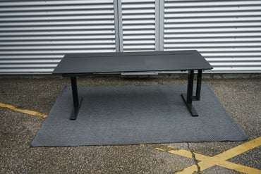 Holmris B8 hæve-sænkebord set forfra i sort med skuffe, computerholder og praktisk kabelgennemføring, 180x80 cm.