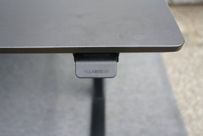 Kontrolknap til højdejustering på Holmris B8 hæve-sænkebord i sort linoleum