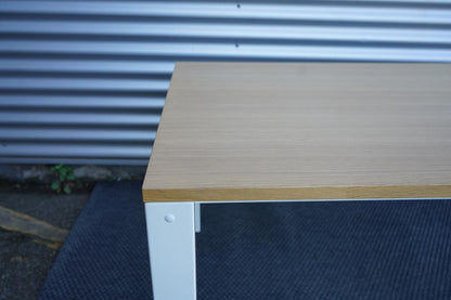 Close-up af Holmris H4 hæve-sænkebord med egetræ bordplade og detaljer på det hvide stel.