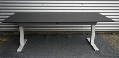 Holmris hæve-sænkebord 200x100 i sort linoleum set bagfra med kabelbakke og solidt understel.