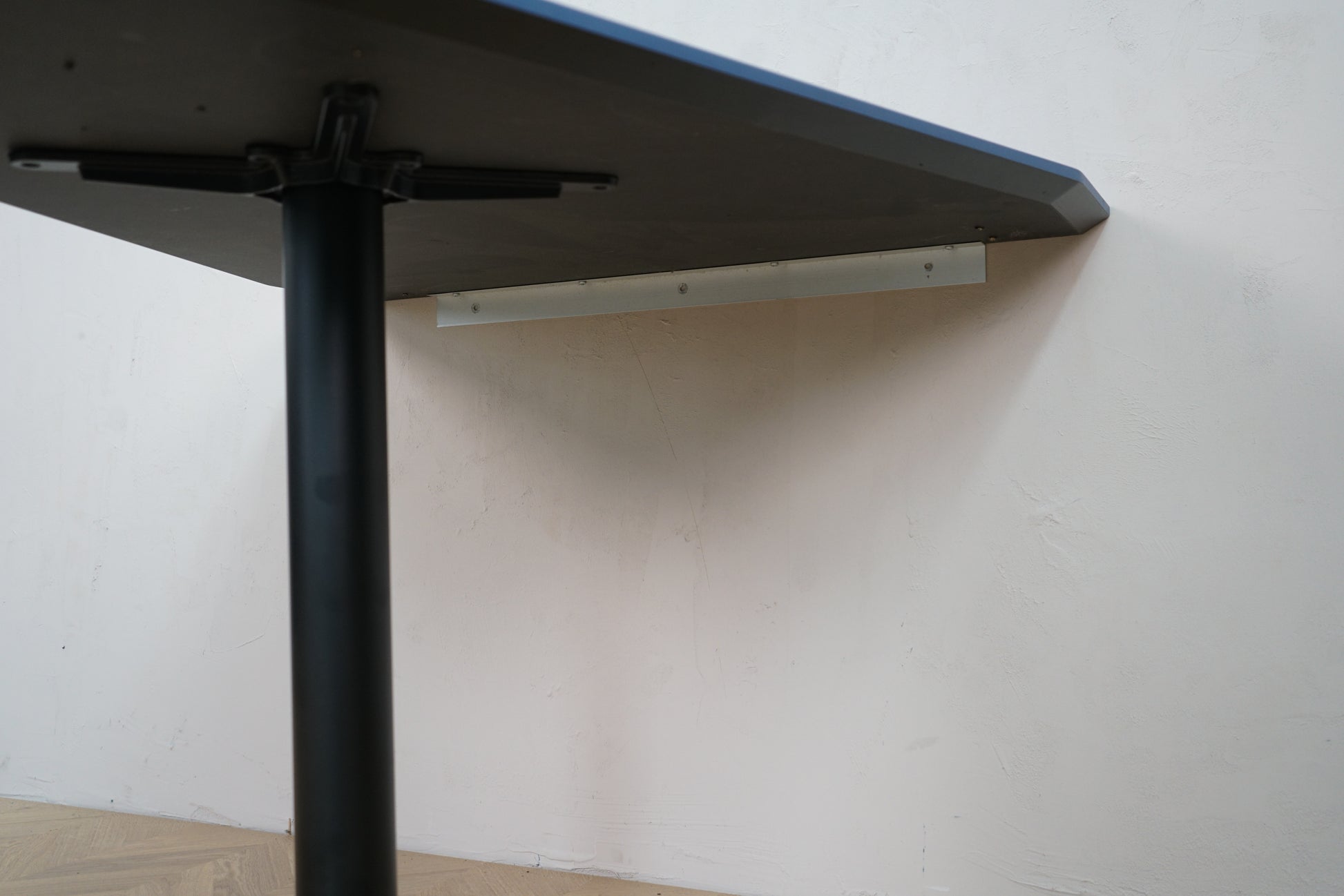 Underside af Holmris vægmonteret bord 120x100 – med vægbeslag og søjlefod