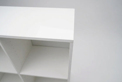 Nærbillede af hvid laminatreol med sokkel og åbne opbevaringsrum til kontor og hjemmekontor.