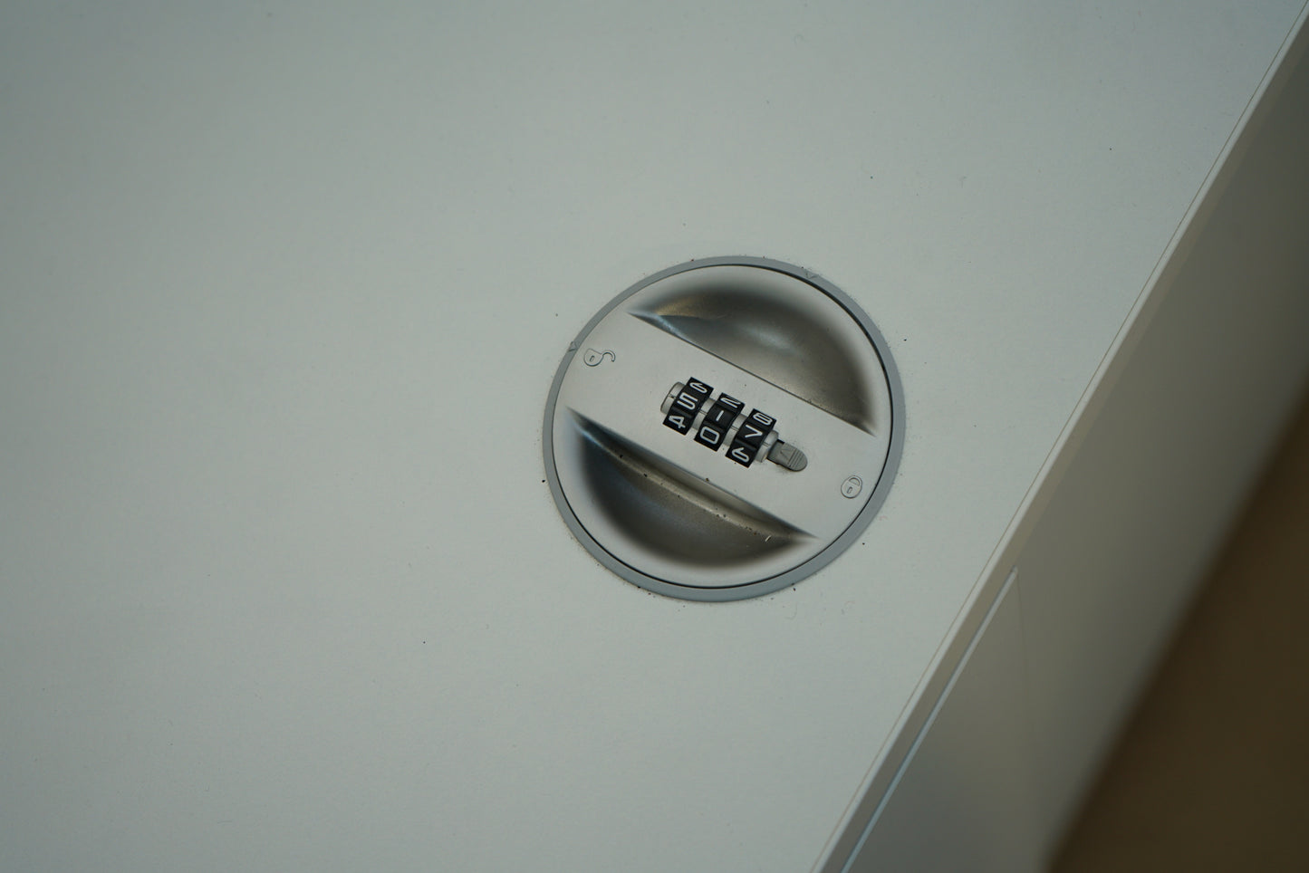 Close up af kombinationslås på hvidt skab med skydedøre
