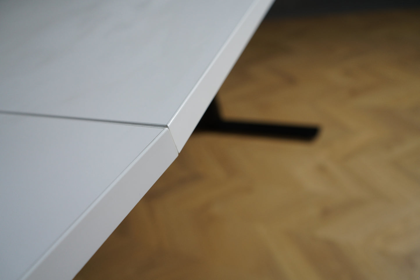 Close up af kantprofil på hvidt tøndeformet mødebord i laminat