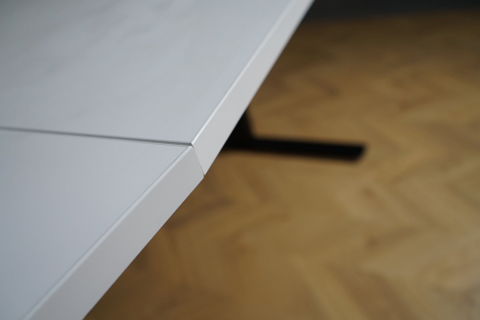 Close up af kantprofil på hvidt tøndeformet mødebord i laminat