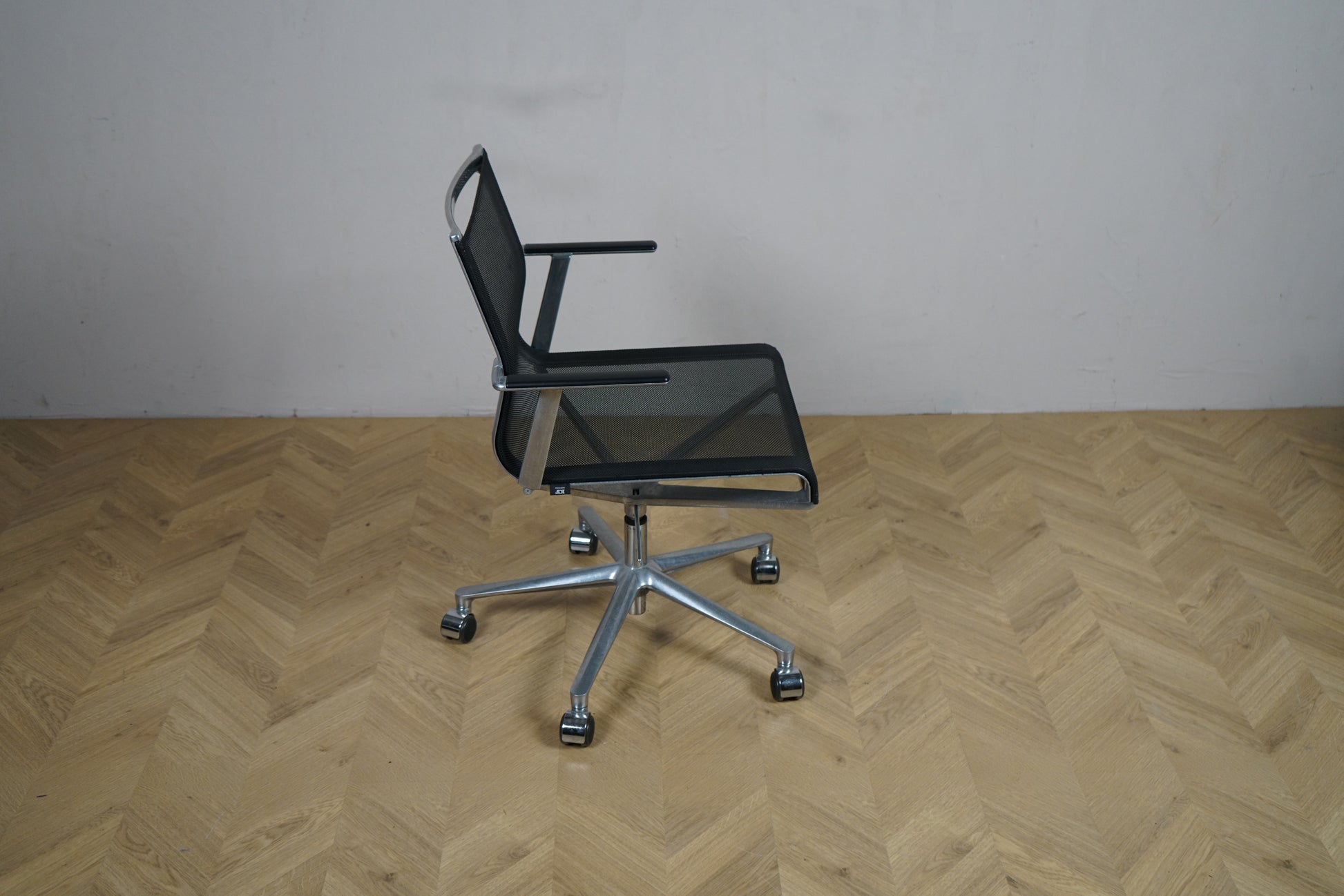 ICF kontorstol set fra siden med armlæn og elegant aluminiumsstel.
