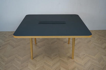 Forum-konferencebord fra Icons of Denmark 140x140 cm – set forfra med sort linoleumsplade og egetræsben