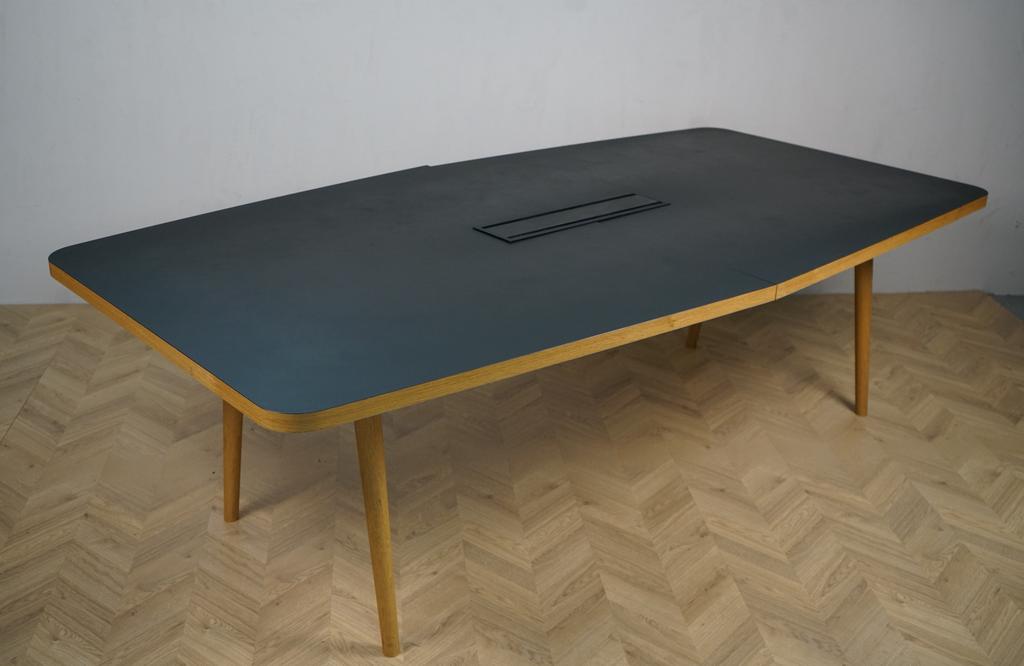 Skrå visning af ICONS OF DENMARK Forum konferencebord med sort linoleum bordplade og egetræsben – 250x130 cm.