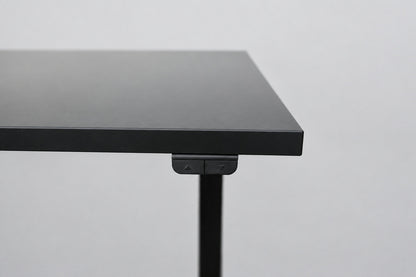 Close up af IKEA hæve-sænkebord med sort laminatbordplade og sort stel
