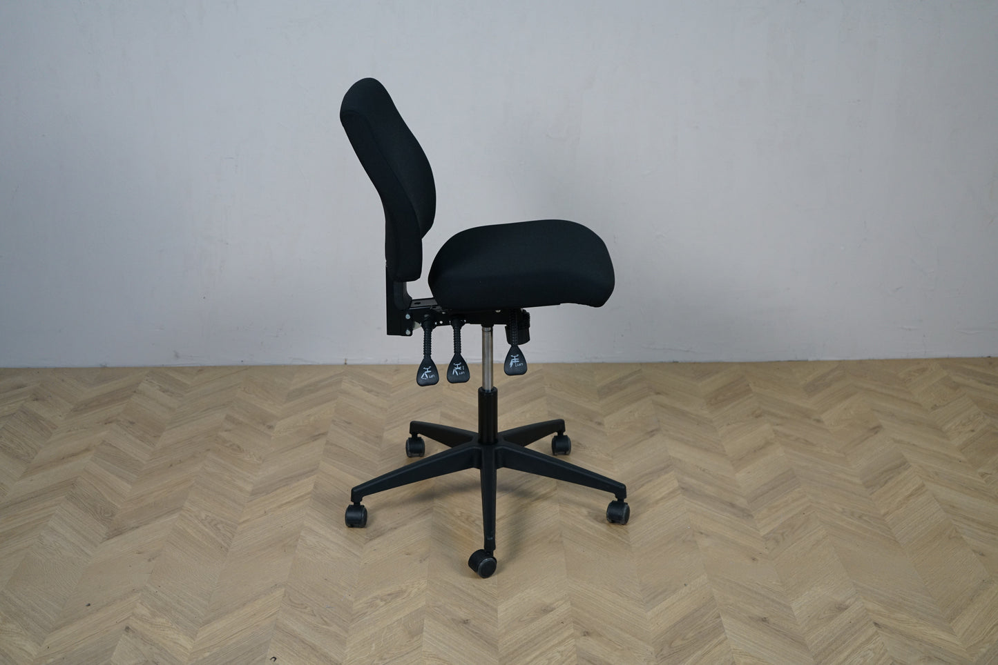 Interstuhl 16GD1 kontorstol set fra siden med sædevip, højdejusterbar ryg og sort fodkryds.