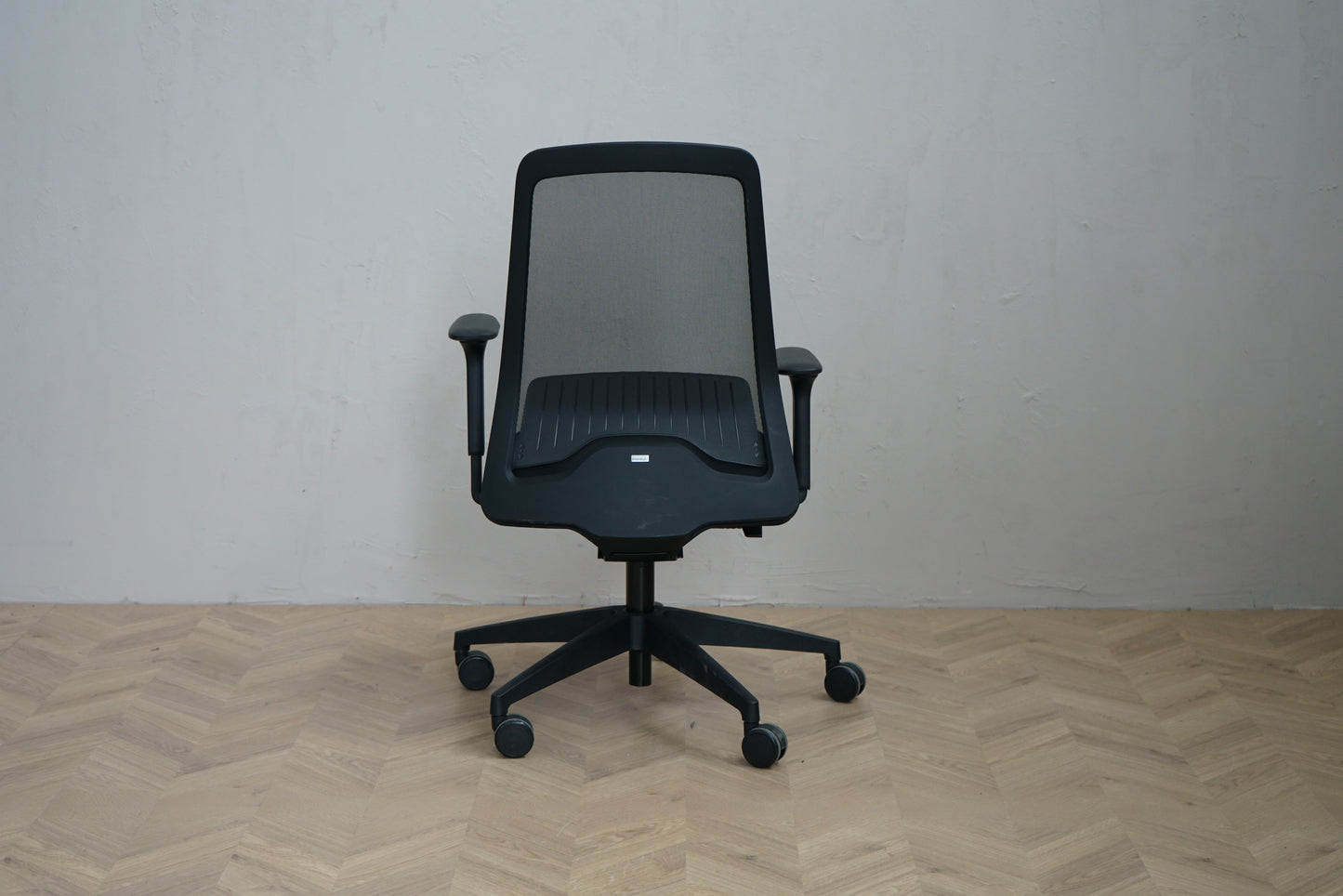Interstuhl Every 251-ery kontorstol sort med ventilerende mesh-ryg og armlæn set bagfra