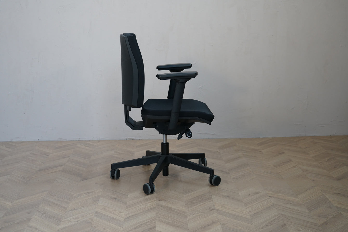 Interstuhl kontorstol set fra siden med armlæn og ergonomisk form