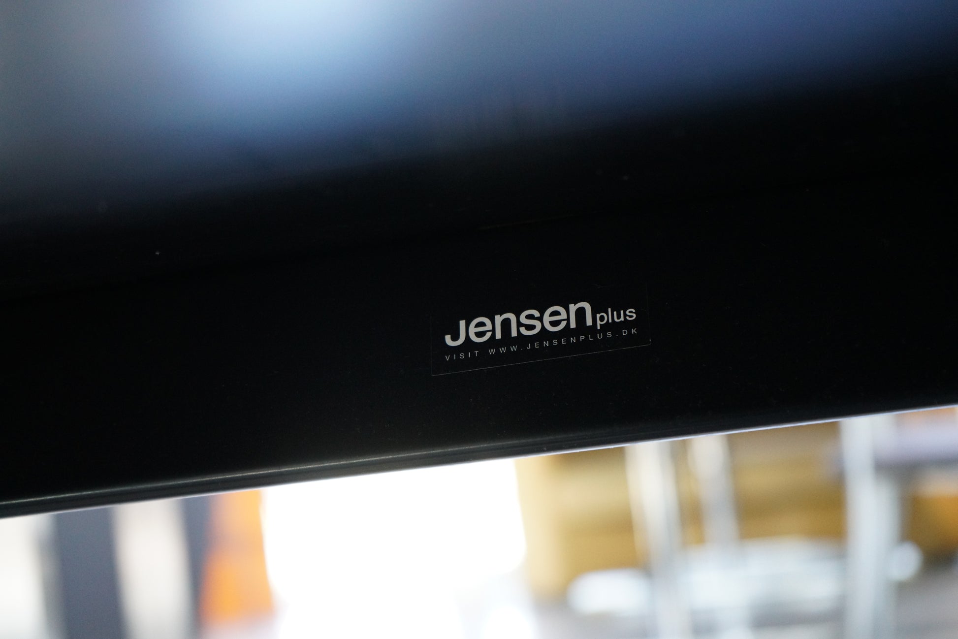 JensenPlus logo på konferencebord i sort linoleum