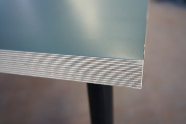 Close-up af lyseblå laminatbordplade med synlig birkefiner kant