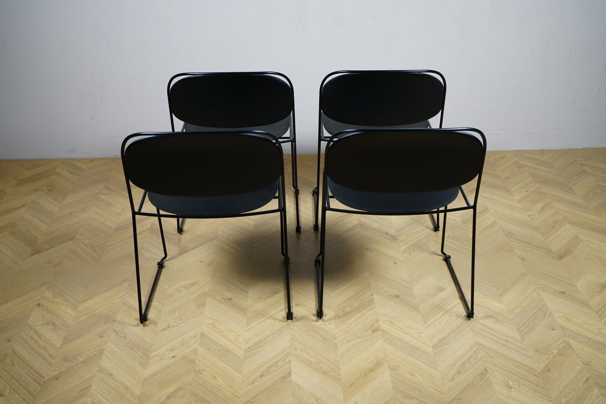 Sæt af 4 sorte Kinnarps stole set bagfra – stilrene og praktiske stole velegnet til kantine, kontor, spisestue eller mødelokale.