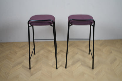 To Kinnarps barstole i lilla stof med sort stel set bagfra