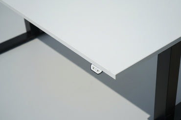 Close up af Kinnarps hæve-sænkebord med hvid laminatbordplade i slidstærk kvalitet og elegant finish.