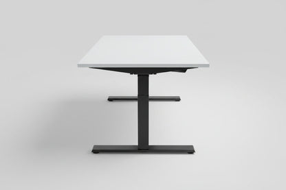 Kinnarps hæve-sænkebord 140x80 cm set fra siden med hvid laminatbordplade, sort stel og sort kabelbakke.