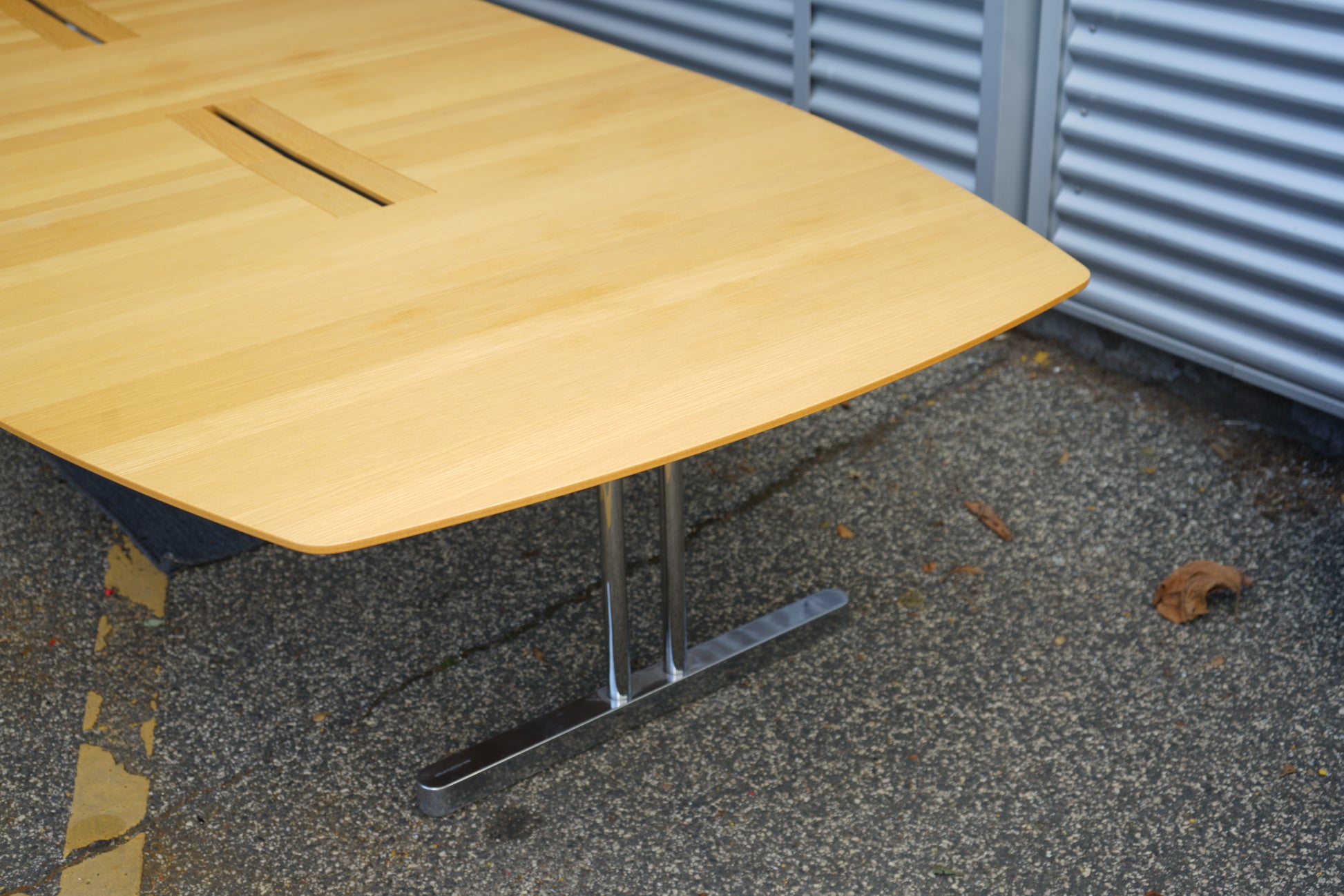 Detalje af Kinnarps mødebord 500x160 cm – massivt egetræsbordplade med elegante kabelgennemføringer og robust krom stel