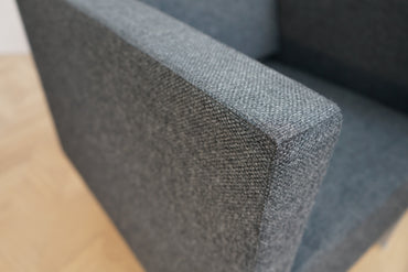 Close up af Kinnarps Pio loungestol i mørkegrå polyester – detaljer i stof og komfort