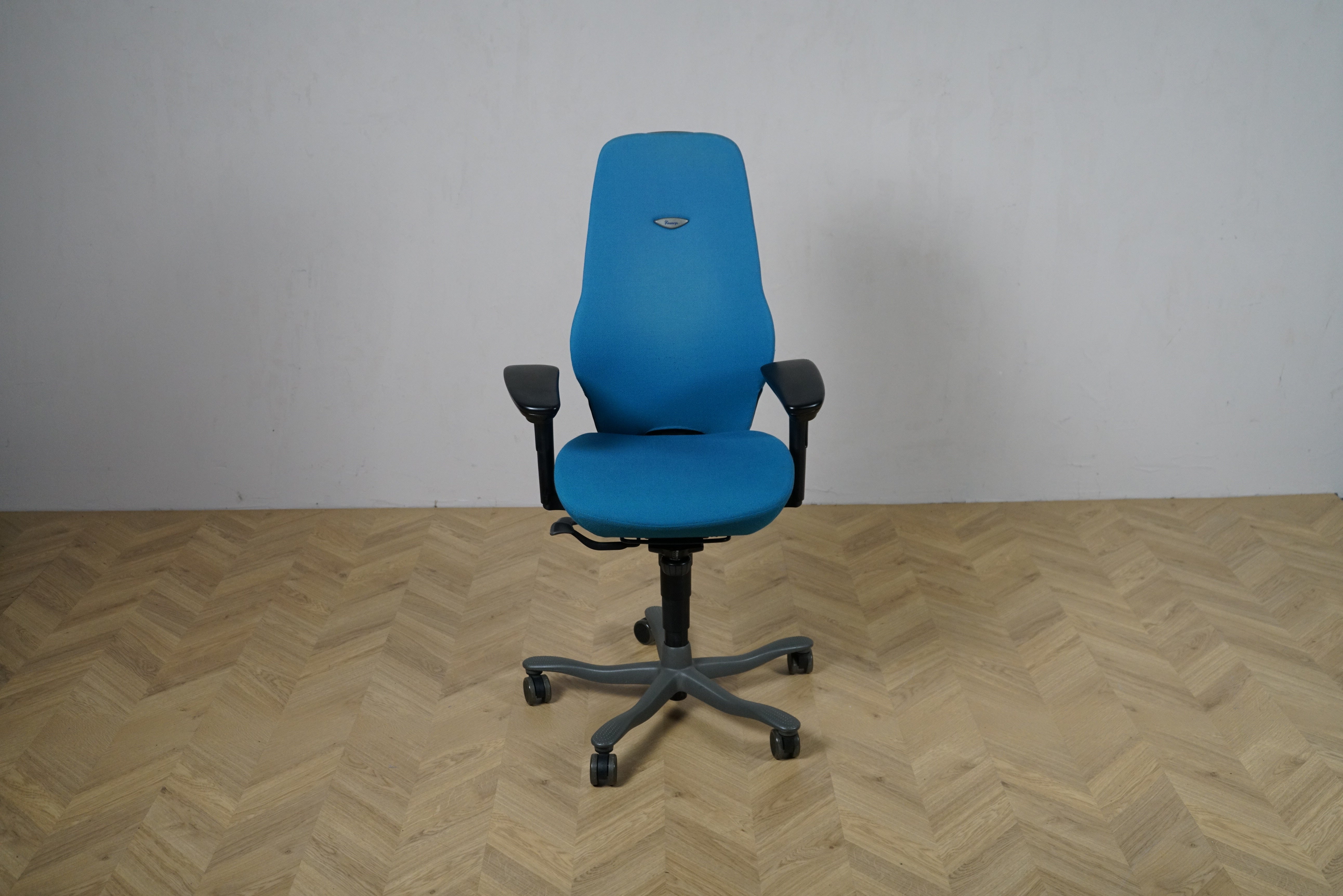 Kinnarps Plus turkis kontorstol set forfra med armlæn og ergonomisk design