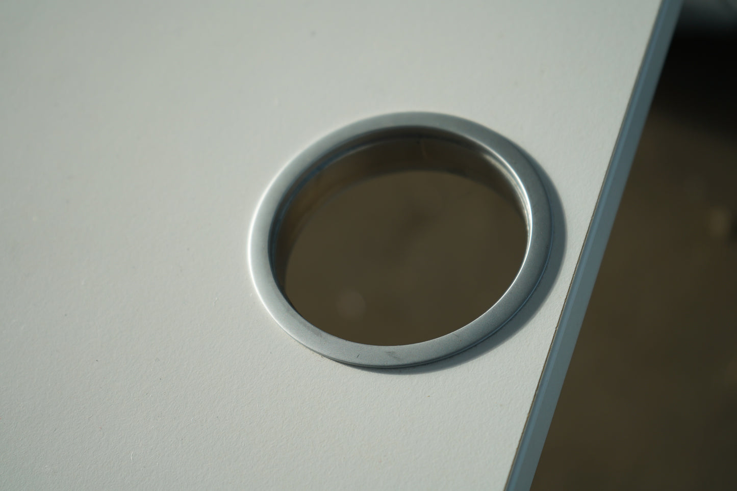 Kabelgennemføring på Kinnarps T-Serie hæve-sænkebord til nem og organiseret kabelstyring.