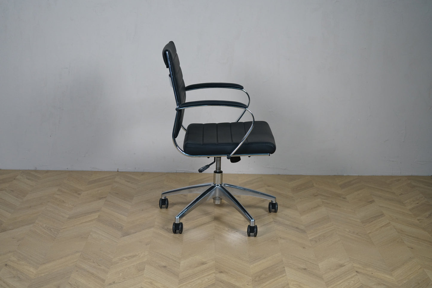 Konferencestol i sort kunstlæder med krom armlæn og hjul – sidevisning