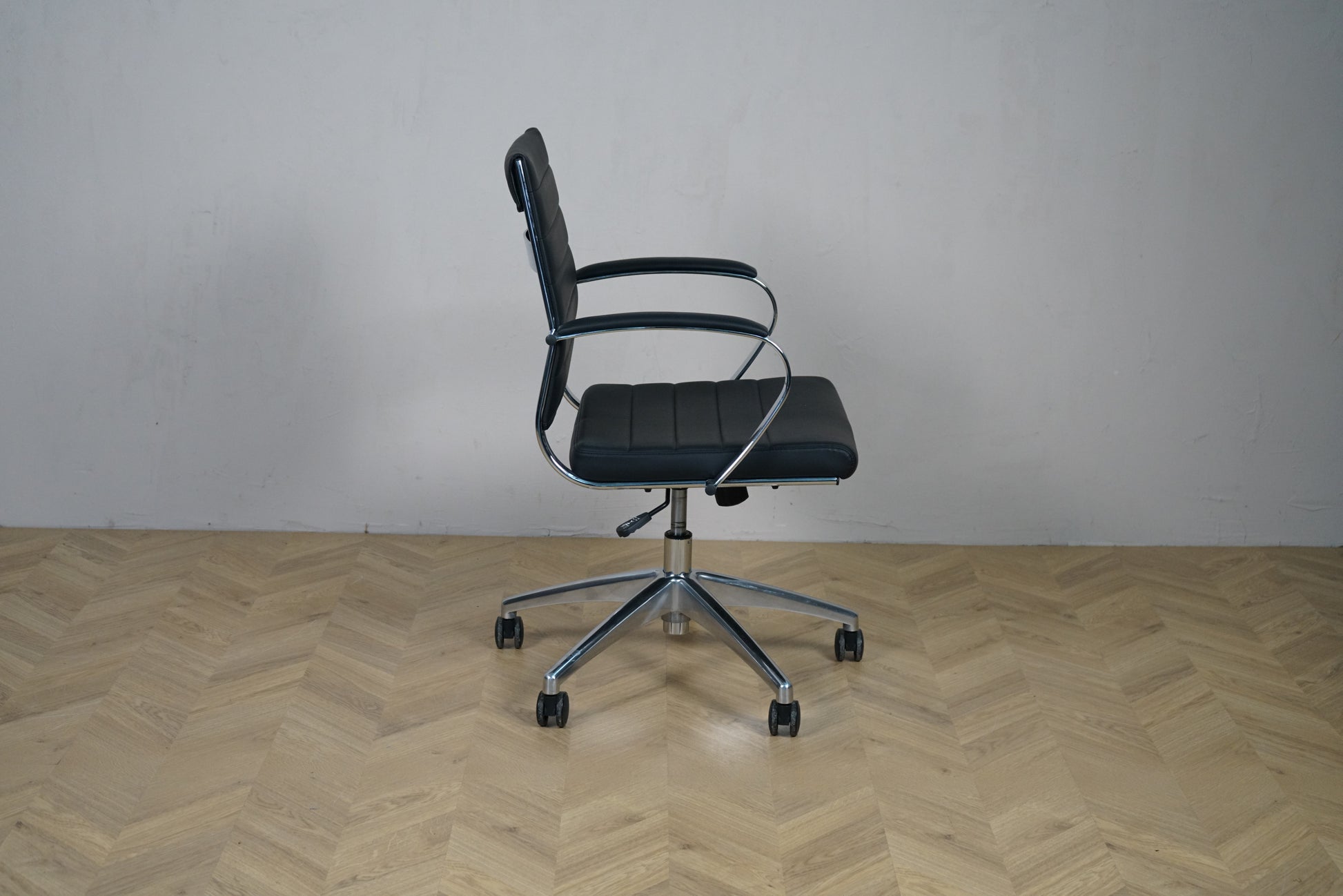 Konferencestol i sort kunstlæder med krom armlæn og hjul – sidevisning