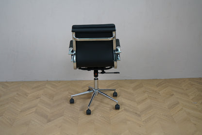 Konferencestol i sort læder set bagfra med krom stel og fodkryds