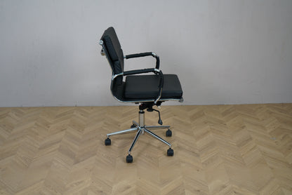 Konferencestol i sort læder set fra siden med lav ryg og armlæn