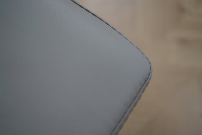 Close-up af lysegrå kunstlæder på kontorstol med fine syninger