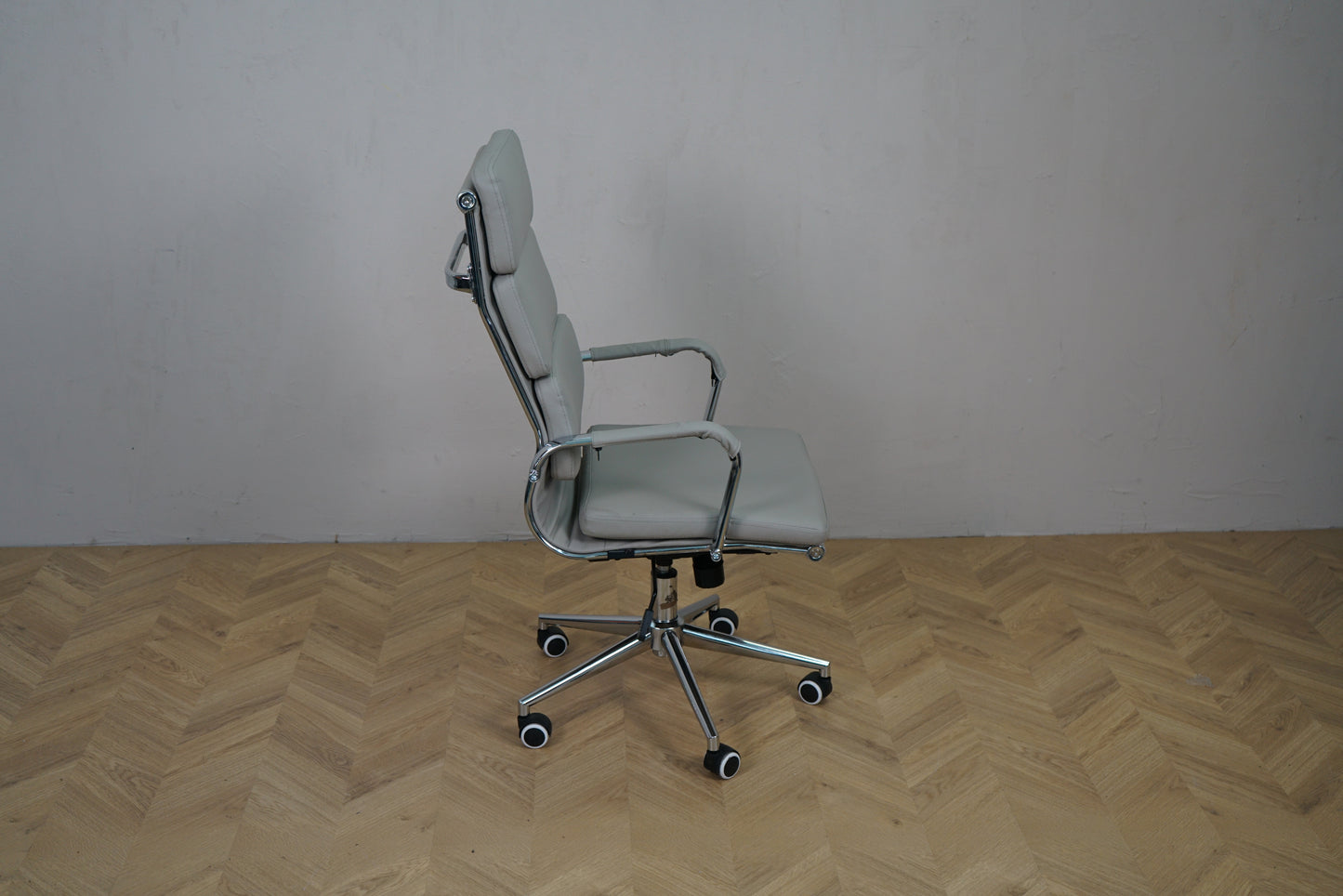 Kontorstol i lysegrå kunstlæder set fra siden med armlæn og hjul