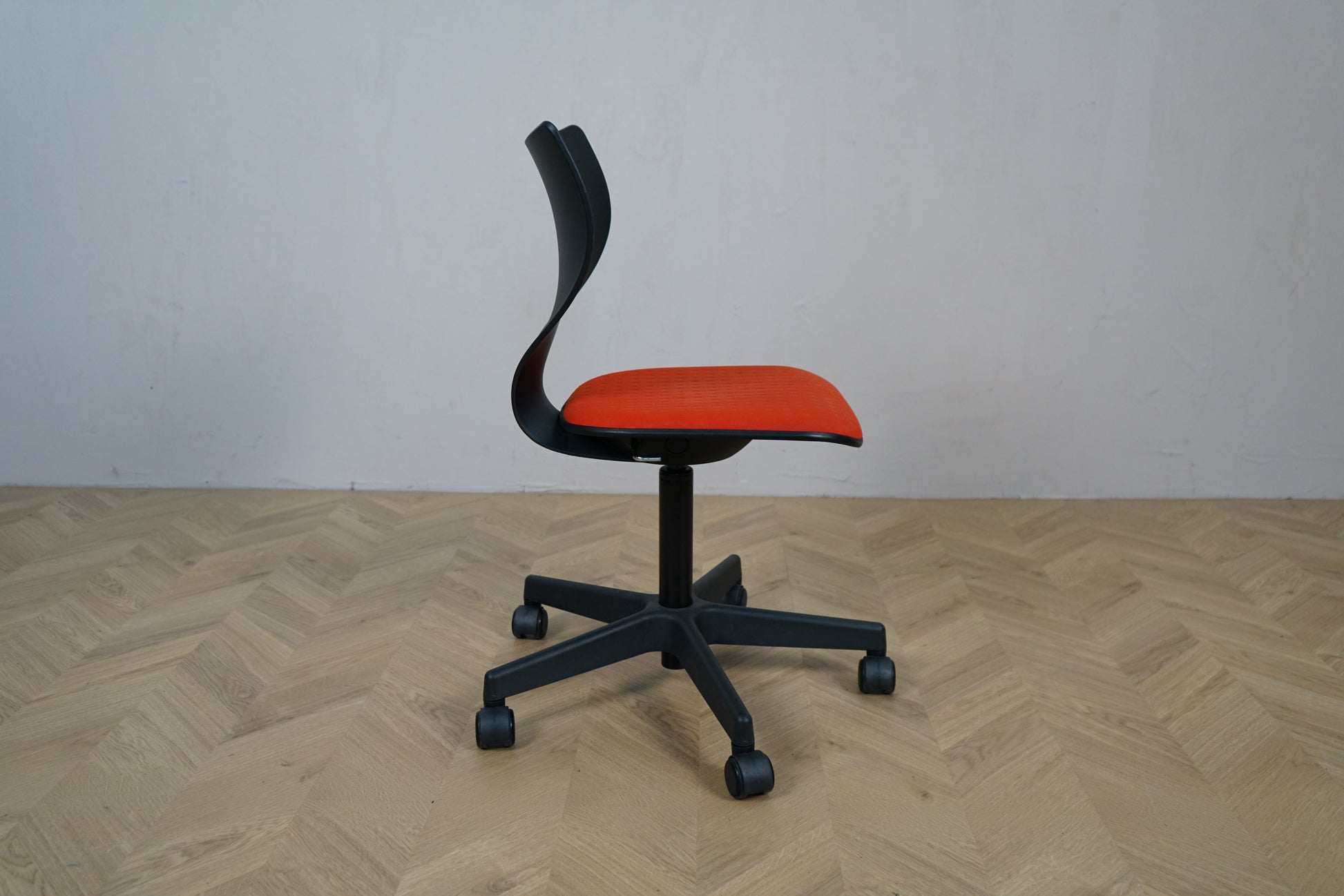 Labofa Cobra kontorstol med sort ryg og orange sæde set fra siden.