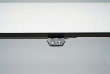 Close up af LINAK hæve-sænkebord med slidstærk hvid laminatbordplade og elegant sort kant.