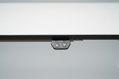 Close up af LINAK hæve-sænkebord med slidstærk hvid laminatbordplade og elegant sort kant.