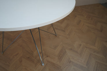 Close up af Magis rundt spisebord med hvid bordplade og elegante kromben.