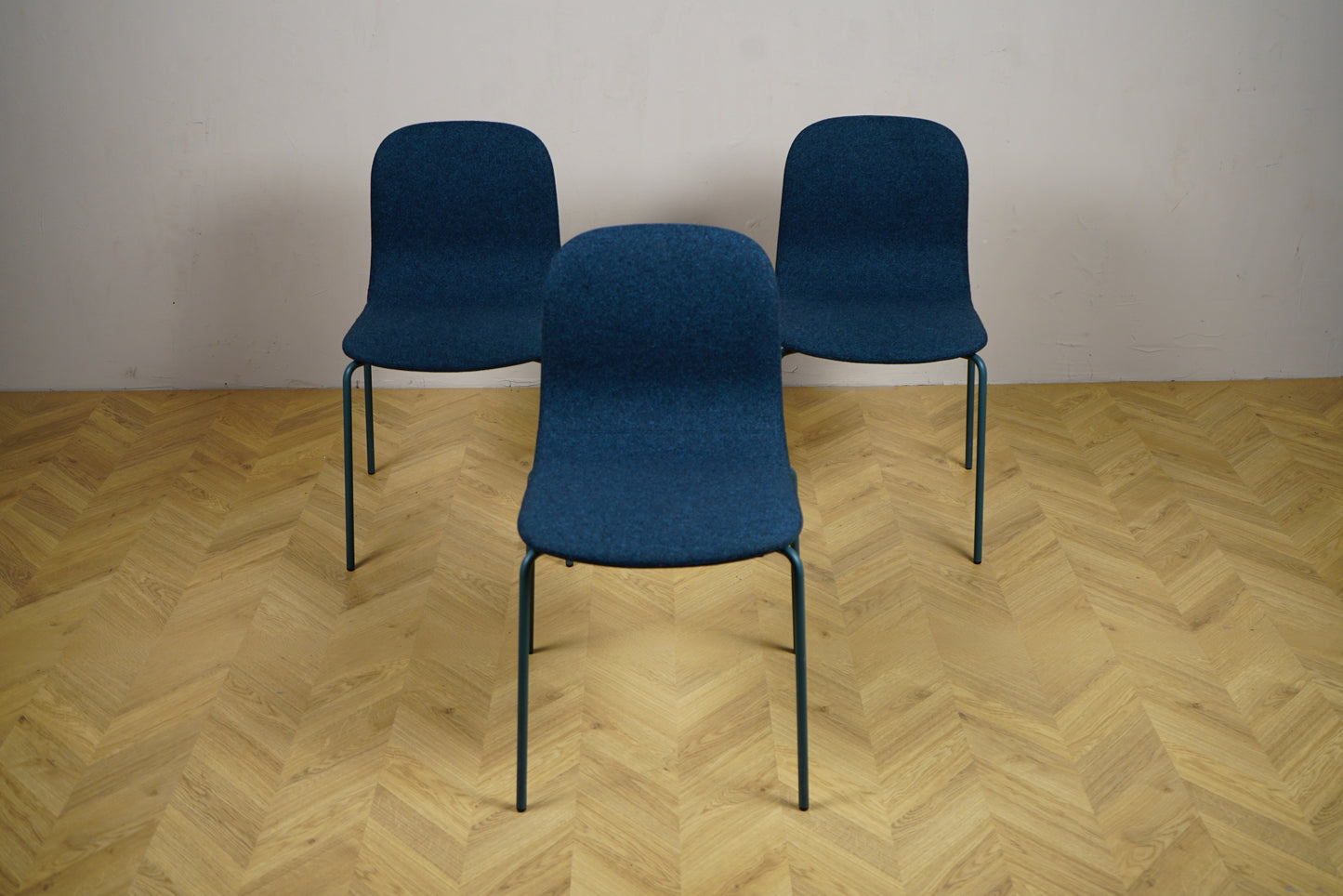 Frontbillede af 3 Materia stabelbare stole i mørkeblå uldstof med siddehøjde 46 cm – ideel som spisestol, mødestol eller loungestol.