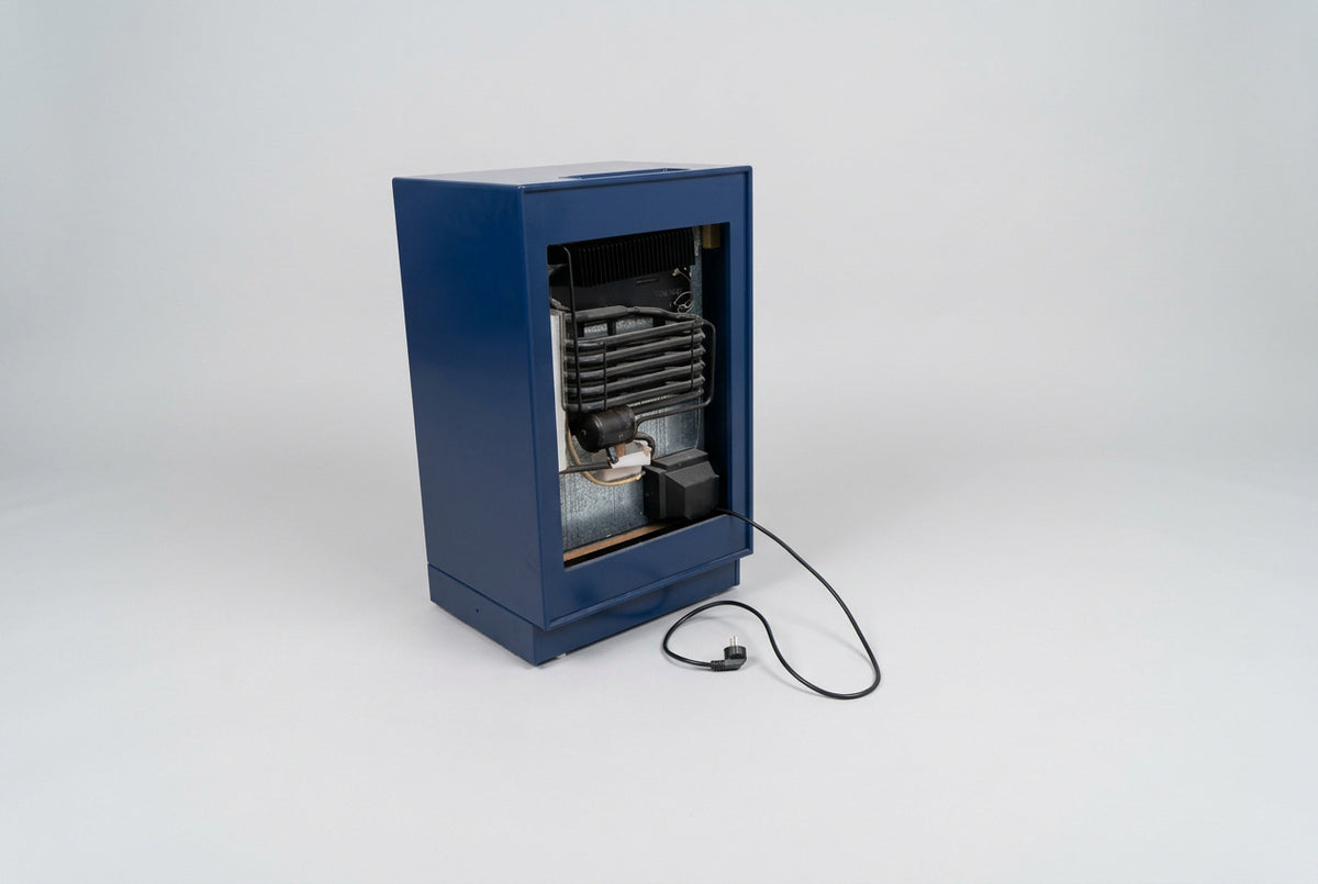Montana minibar og lille køleskab i mørkeblå med sokkel, velegnet til kontor, lounge og mødelokale, set bagfra.