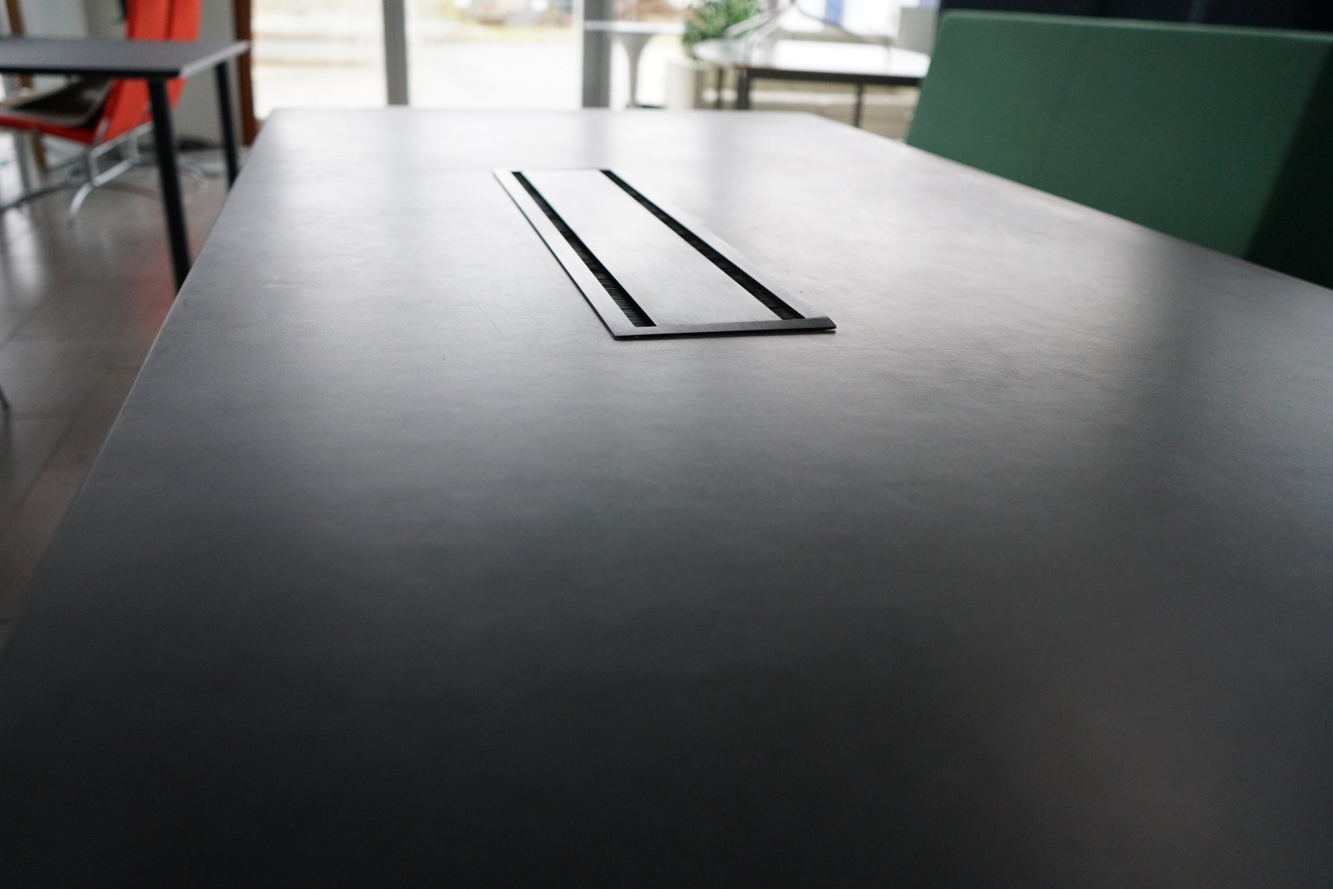 Close-up af sort bordplade og detaljer på Montana mødebord med kabelgennemføring.