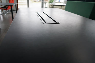 Close-up af sort bordplade og detaljer på Montana mødebord med kabelgennemføring.