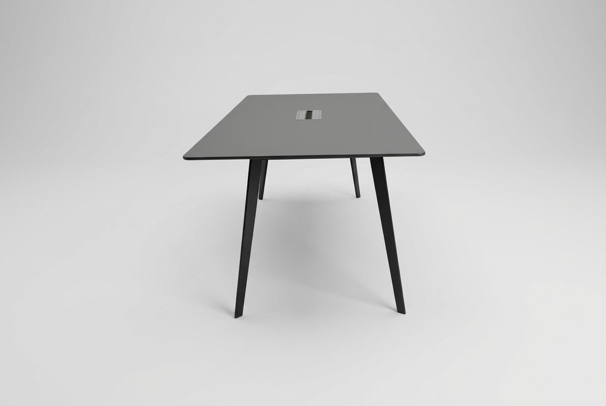 Montana mødebord i sort laminat med slanke, skråtstillede sorte ben og elegant design, set fra siden.
