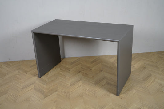 Montana Monterey skrivebord i grå finish set fra en skrå vinkel, 120×60×74 cm, minimalistisk og moderne dansk design.